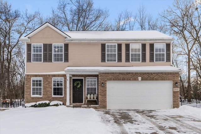 view of front of home featuring a garage, fence, and brick siding