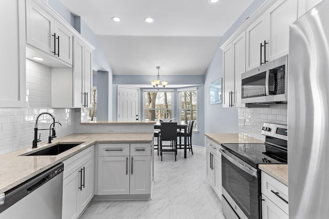 kitchen featuring appliances with stainless steel finishes, white cabinetry, and pendant lighting