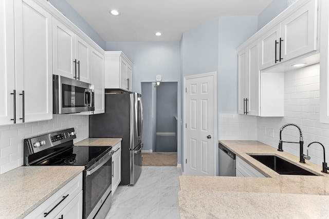 kitchen with white cabinetry, stainless steel appliances, and sink