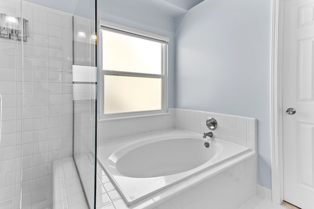 bathroom with a relaxing tiled tub