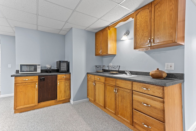 kitchen with light carpet, sink, a paneled ceiling, and dishwasher