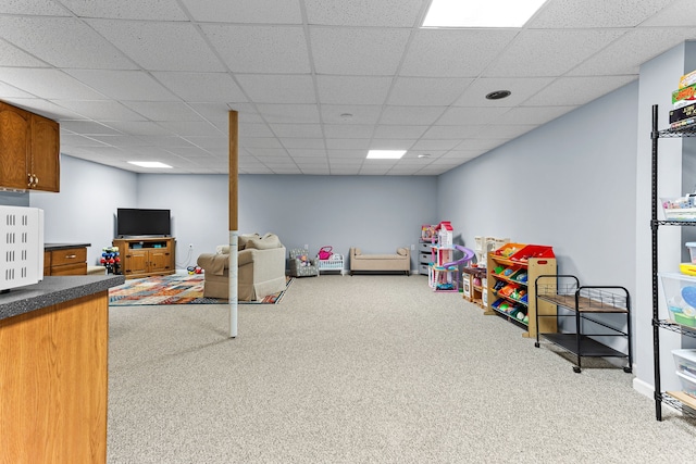 rec room with a paneled ceiling and light colored carpet