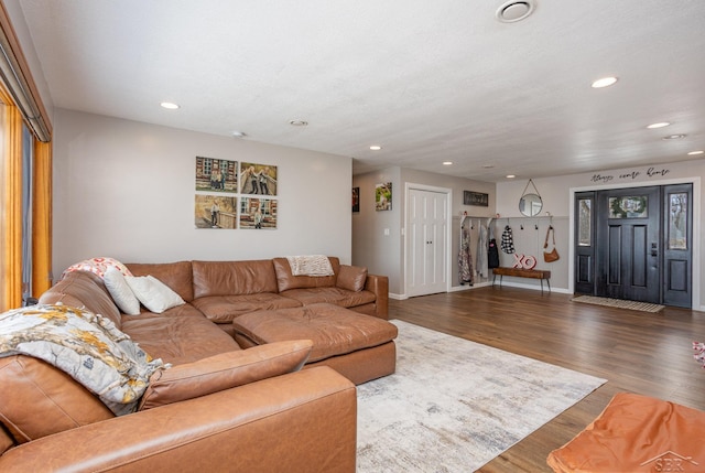 living room with a textured ceiling and dark wood-type flooring