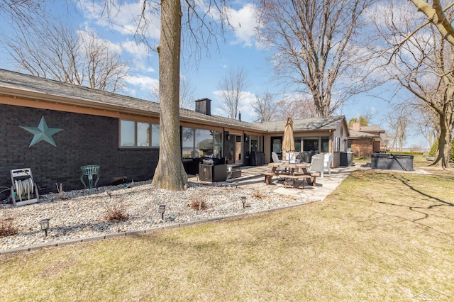 back of house with a patio area, a chimney, and a lawn