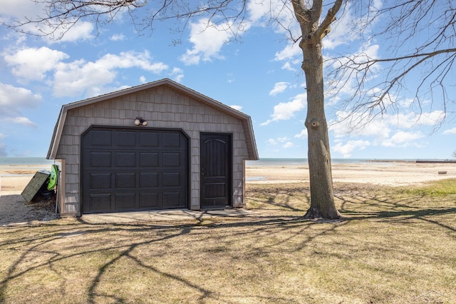 detached garage featuring a beach view and a water view