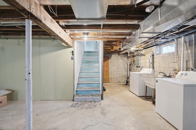 basement featuring washing machine and dryer, a sink, and stairs