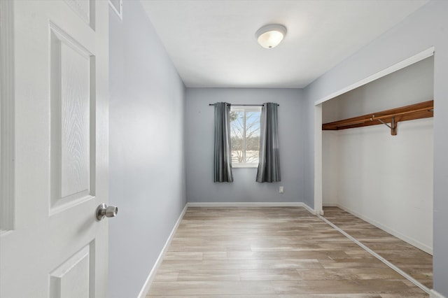 unfurnished room with light wood-style floors and baseboards