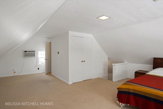 carpeted bedroom featuring vaulted ceiling and an AC wall unit