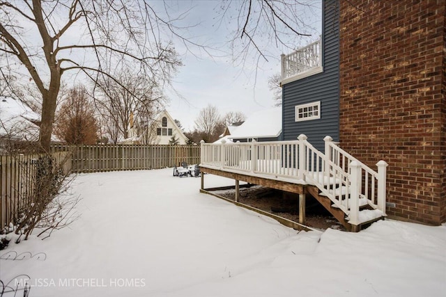 yard covered in snow featuring a deck