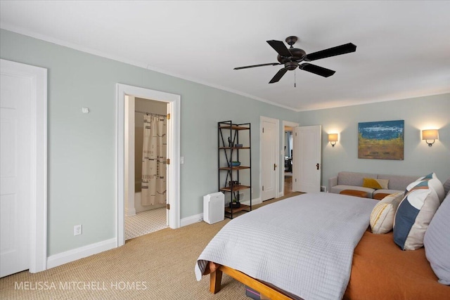 carpeted bedroom featuring ceiling fan, crown molding, and ensuite bathroom