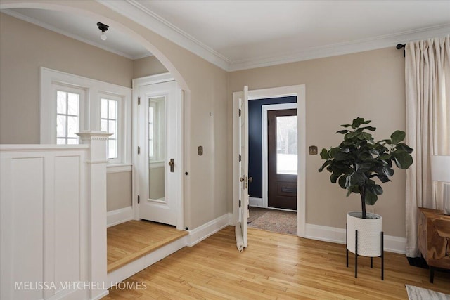 foyer entrance featuring a healthy amount of sunlight, light hardwood / wood-style flooring, and ornamental molding