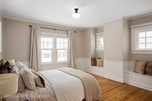 bedroom with ornamental molding and light hardwood / wood-style flooring