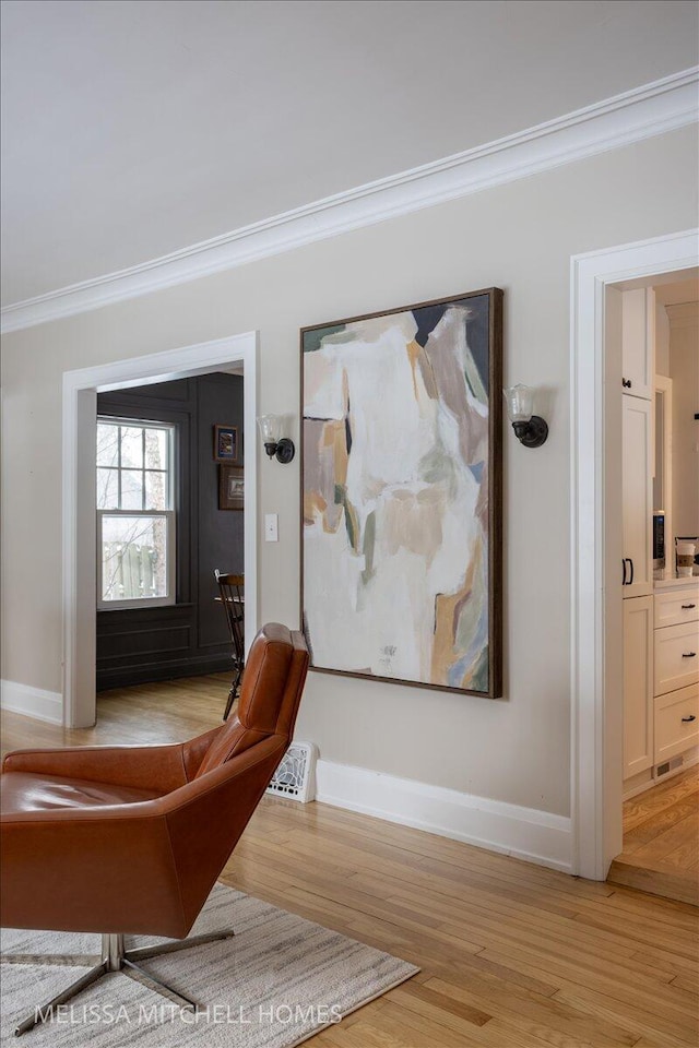 foyer entrance featuring crown molding and light hardwood / wood-style floors