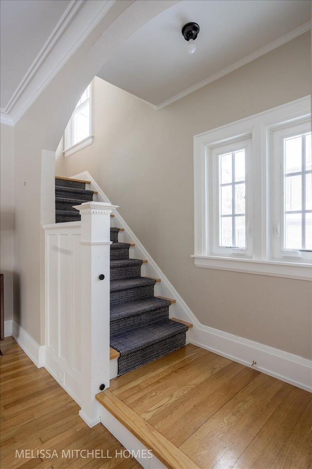 stairway featuring hardwood / wood-style flooring and ornamental molding