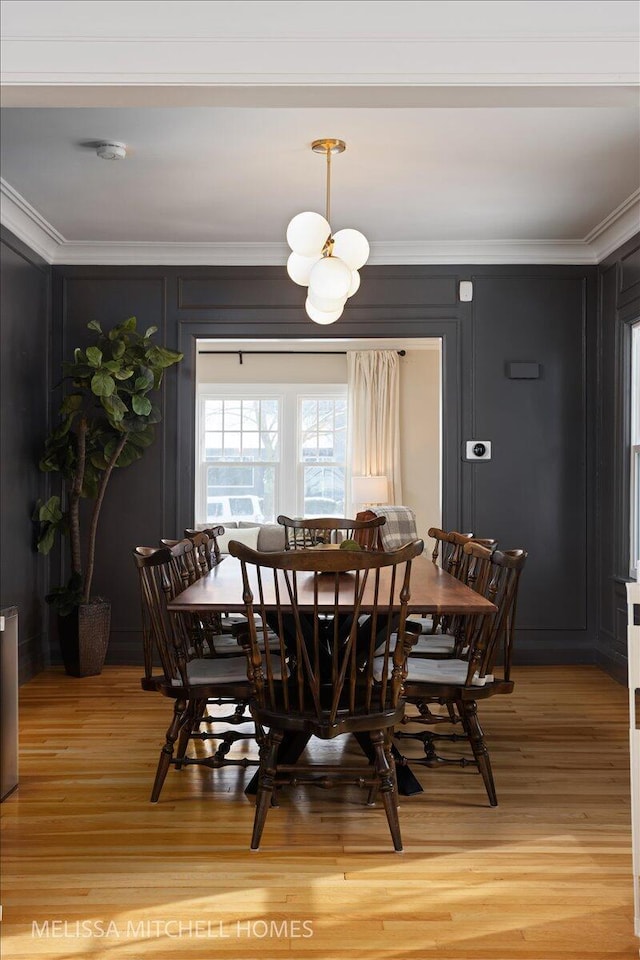 dining area featuring ornamental molding and wood-type flooring