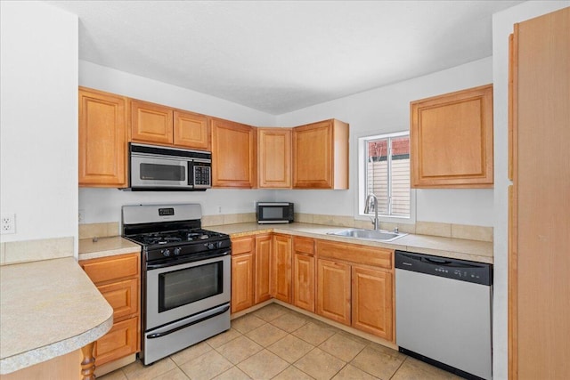 kitchen with appliances with stainless steel finishes, light tile patterned flooring, and sink