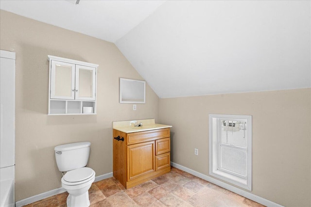 bathroom with toilet, vanity, a bath, and lofted ceiling