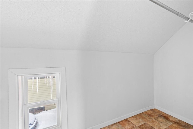 bonus room featuring a textured ceiling and vaulted ceiling