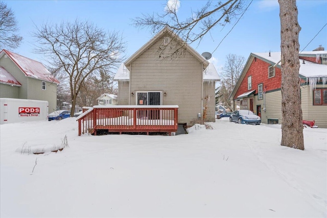 snow covered rear of property featuring a wooden deck