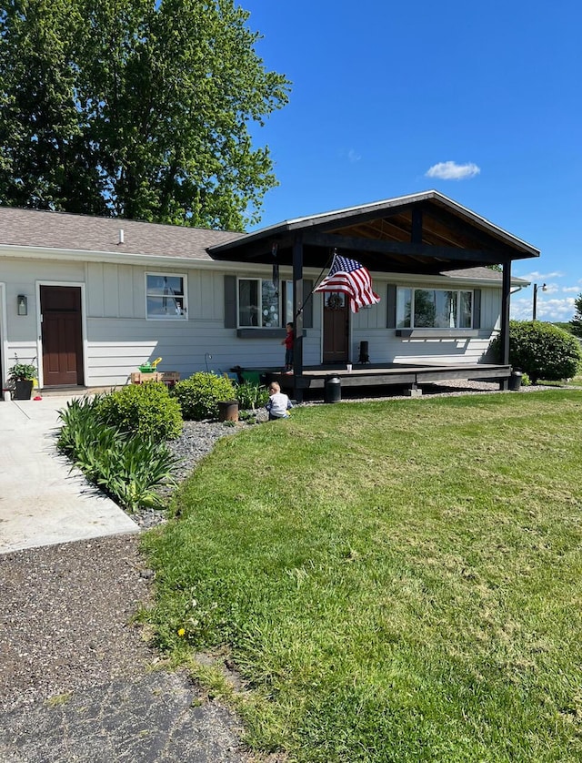 view of front of house featuring board and batten siding, concrete driveway, and a front yard