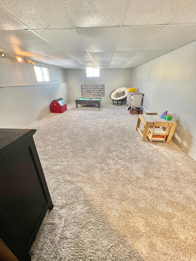 recreation room featuring carpet and a paneled ceiling