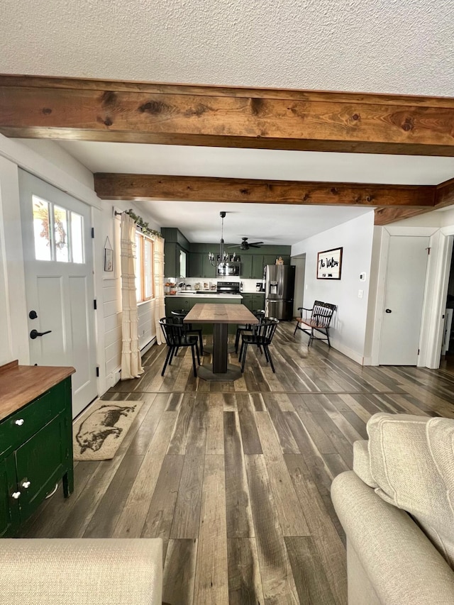 interior space featuring dark wood-type flooring, beam ceiling, a textured ceiling, and baseboards