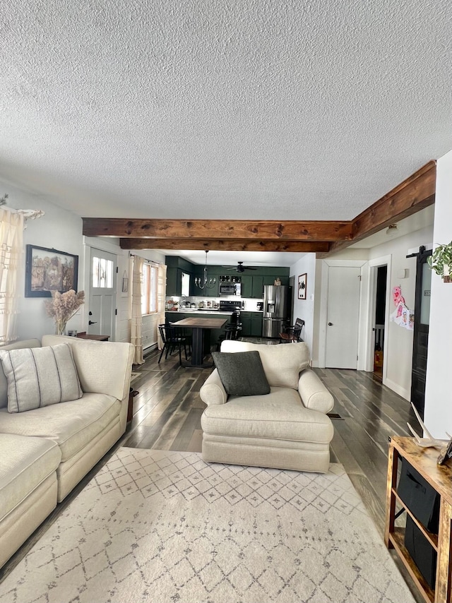 living area featuring beamed ceiling, a textured ceiling, and wood finished floors