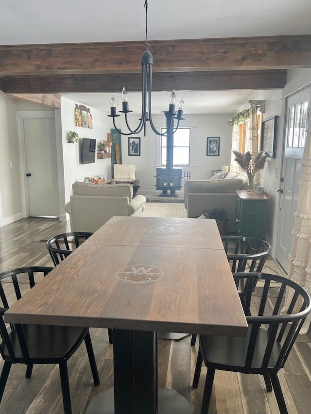 dining space featuring a notable chandelier, wood finished floors, beam ceiling, and baseboards