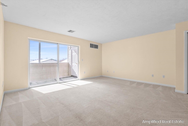 carpeted spare room with a textured ceiling