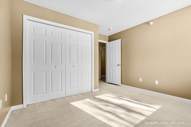 unfurnished bedroom featuring a closet and light carpet