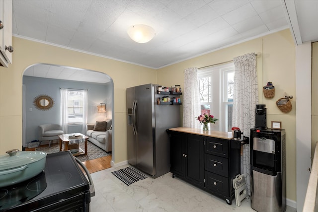 kitchen featuring black range with electric cooktop, crown molding, and stainless steel fridge with ice dispenser