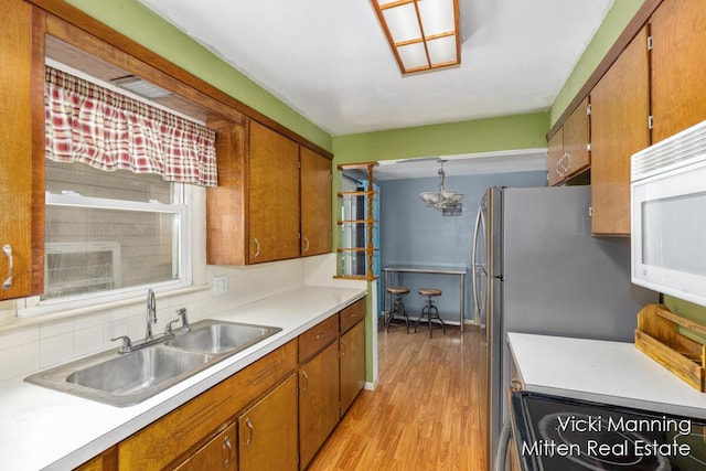 kitchen featuring decorative backsplash, sink, and light wood-type flooring