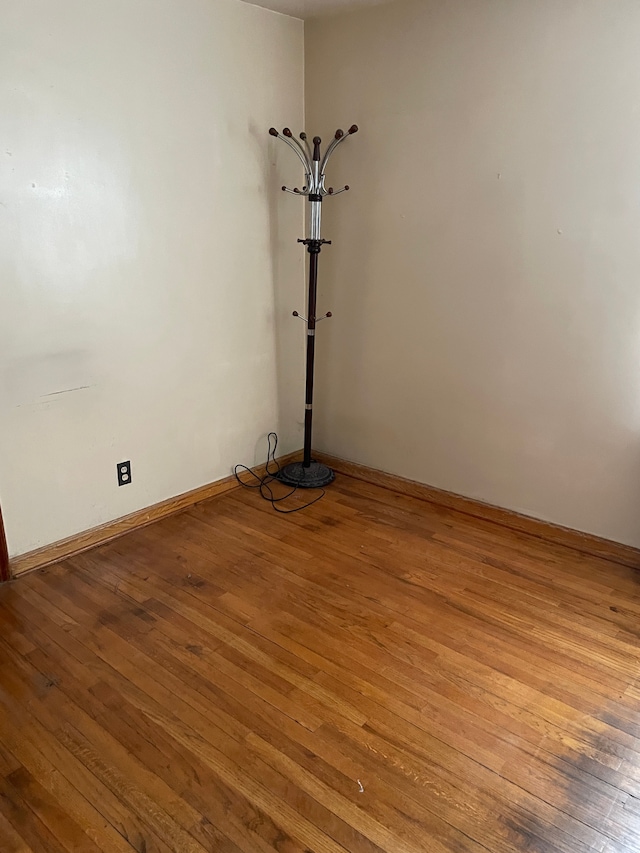 spare room featuring light wood-type flooring and baseboards