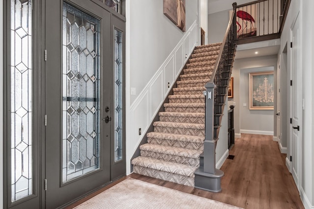 entrance foyer with stairway, wood finished floors, and baseboards