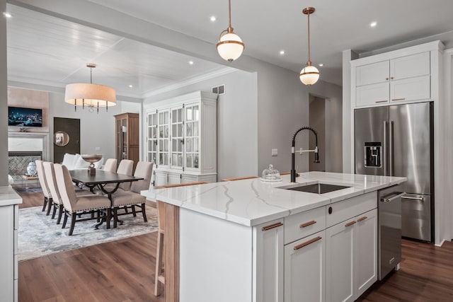 kitchen with pendant lighting, a center island with sink, white cabinetry, a sink, and high end refrigerator