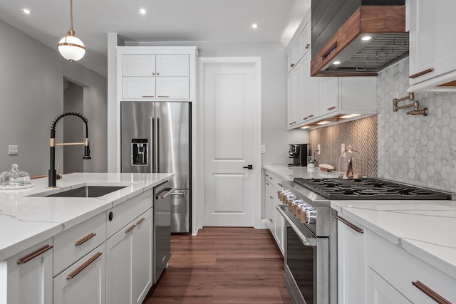 kitchen featuring high end appliances, a sink, and white cabinetry