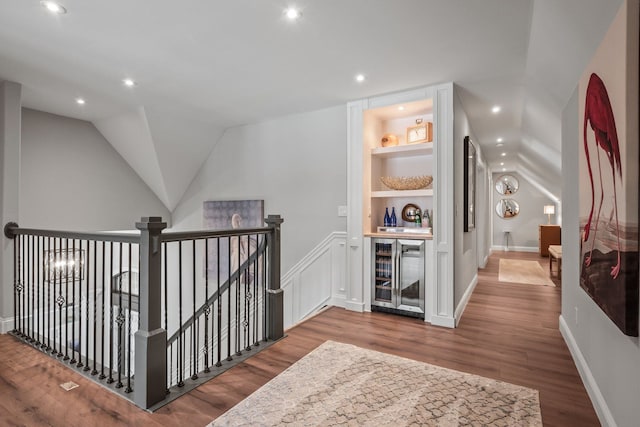 hallway featuring built in features, wine cooler, wood finished floors, an upstairs landing, and recessed lighting