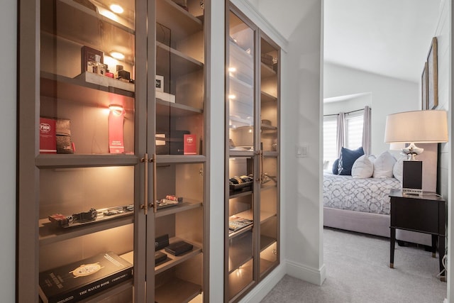 wine room featuring lofted ceiling and light colored carpet