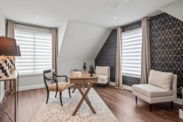 sitting room featuring an accent wall, wood finished floors, and a wealth of natural light