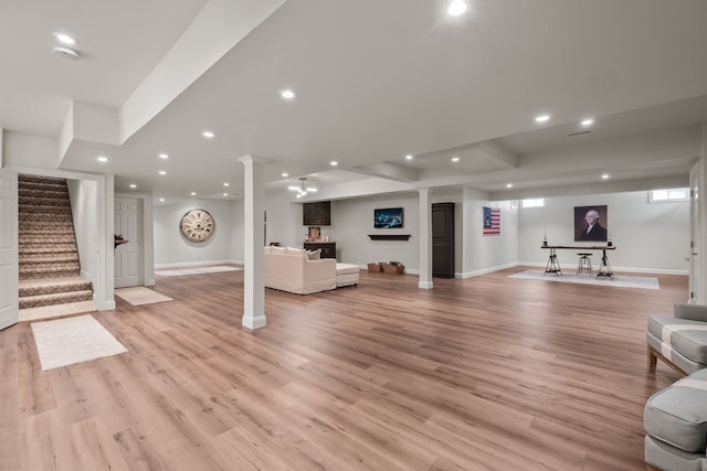 unfurnished living room featuring light wood-style floors, recessed lighting, baseboards, and stairs