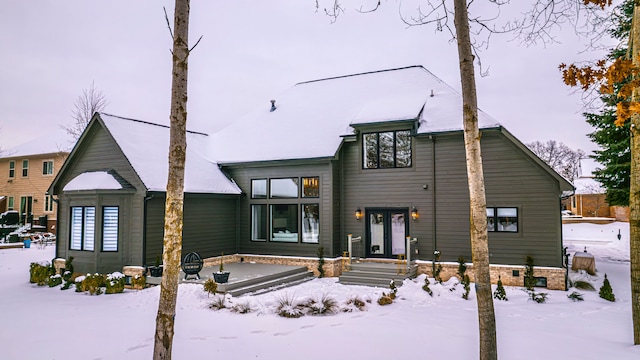 view of snow covered back of property