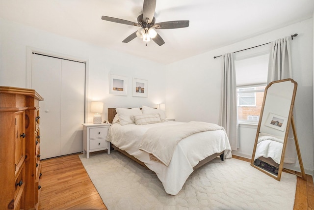 bedroom with hardwood / wood-style flooring, ceiling fan, and a closet