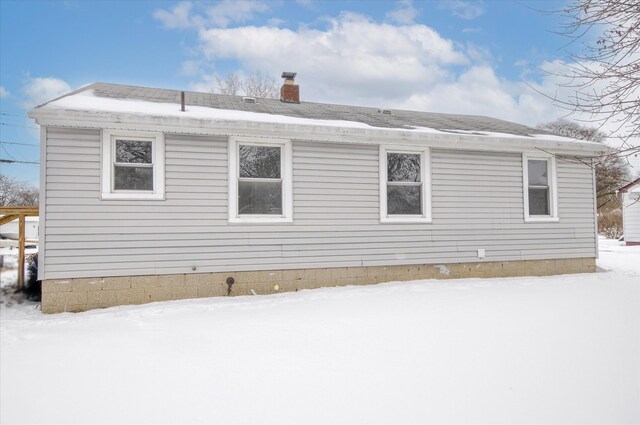 snow covered property featuring a chimney