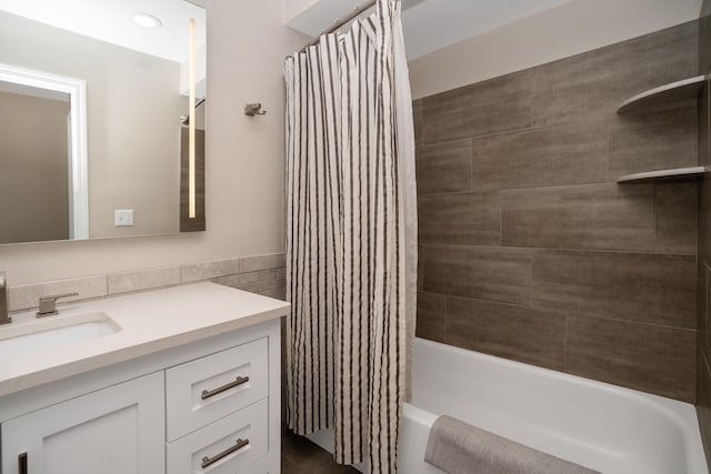 full bathroom with shower / bath combo, tile walls, and vanity