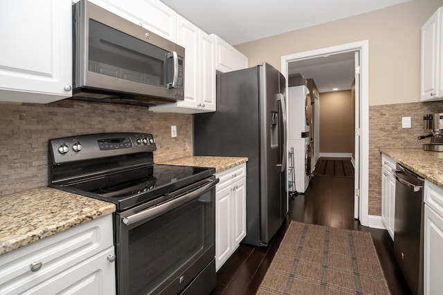 kitchen with light stone countertops, dark wood-style floors, white cabinetry, and stainless steel appliances