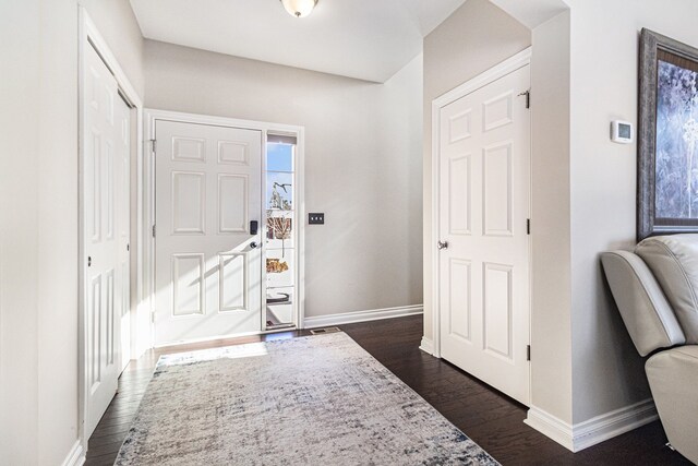 entrance foyer with dark wood-type flooring and baseboards