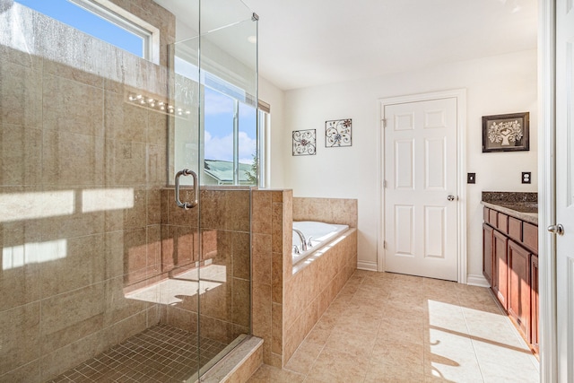 full bathroom with a garden tub, plenty of natural light, vanity, and tile patterned floors