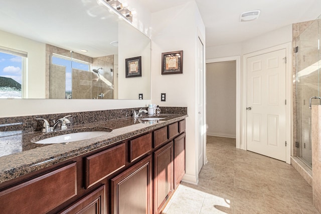 bathroom with double vanity, a stall shower, a sink, and visible vents