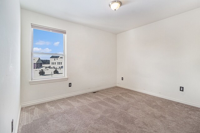 empty room featuring carpet floors and baseboards