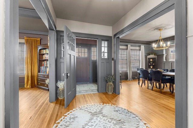 entryway with visible vents, a notable chandelier, and wood finished floors